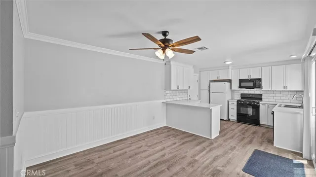 a open kitchen with white cabinets and stainless steel appliances