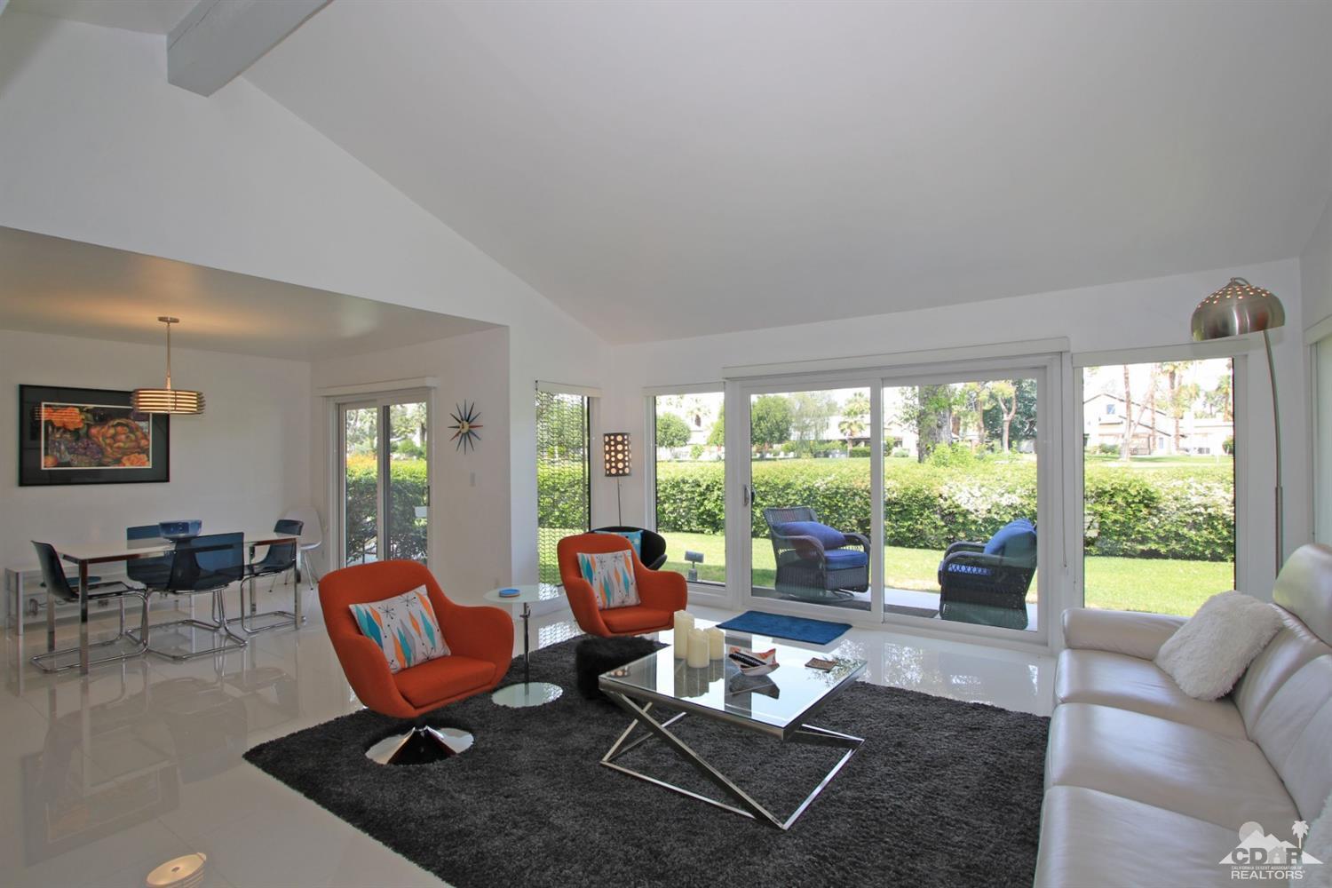 a living room with furniture and a floor to ceiling window