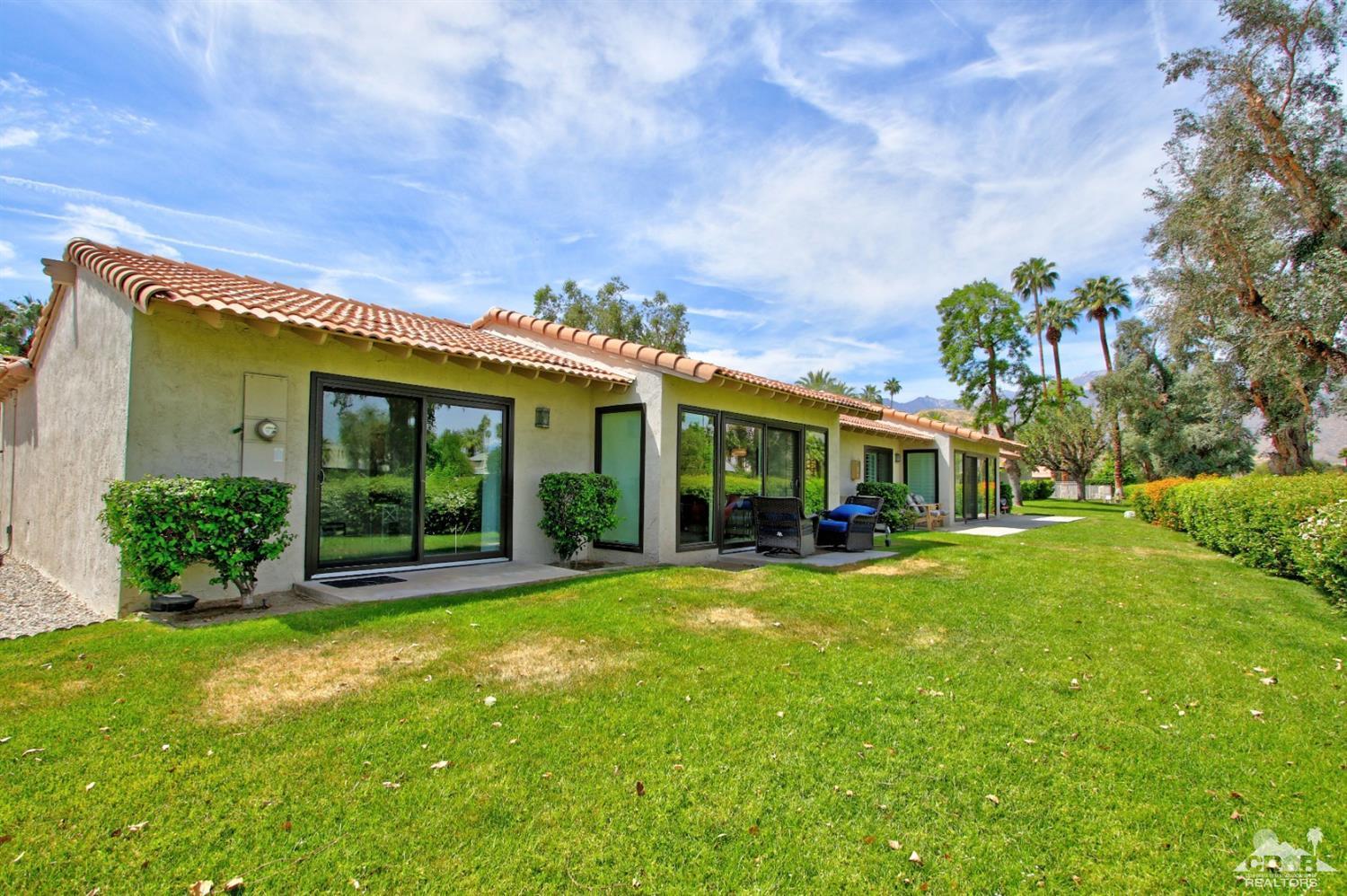 6012 East Driver Road Palm Springs, CA 92264 - Photo 41 of 47 a view of a house with a big yard and potted plants and large trees
