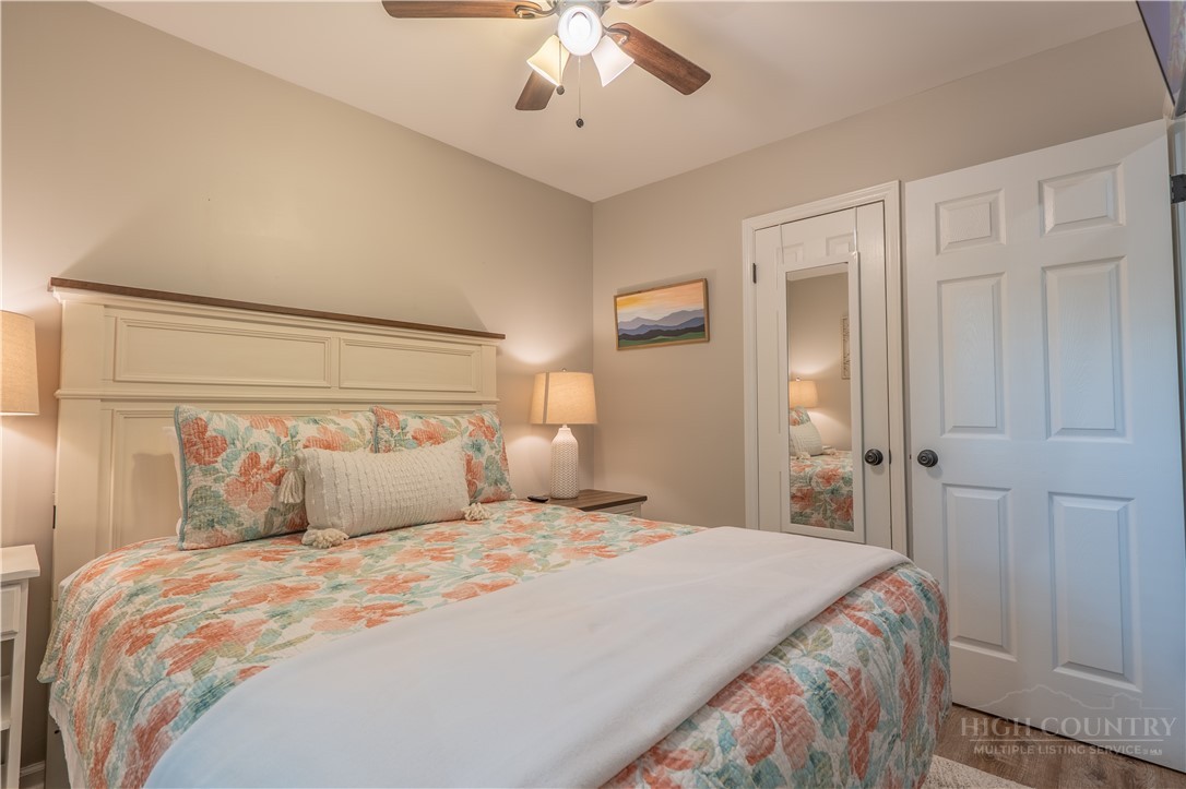 141 Snowflake Road Banner Elk, NC 28604 - Photo 6 of 28 a bedroom with a large bed and a chandelier