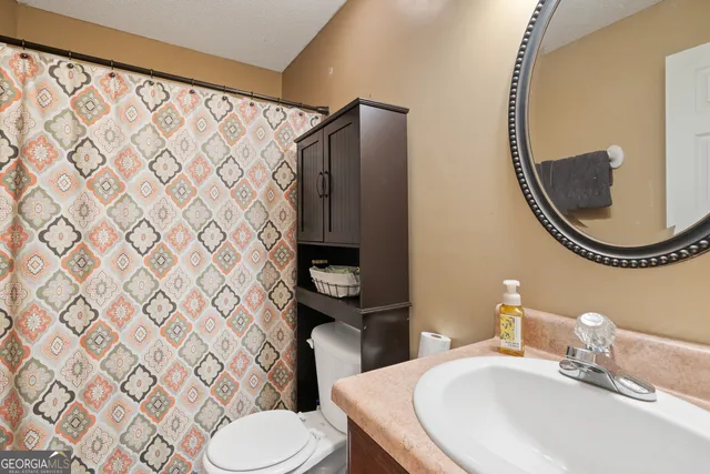 a bathroom with a sink and a mirror with toilet
