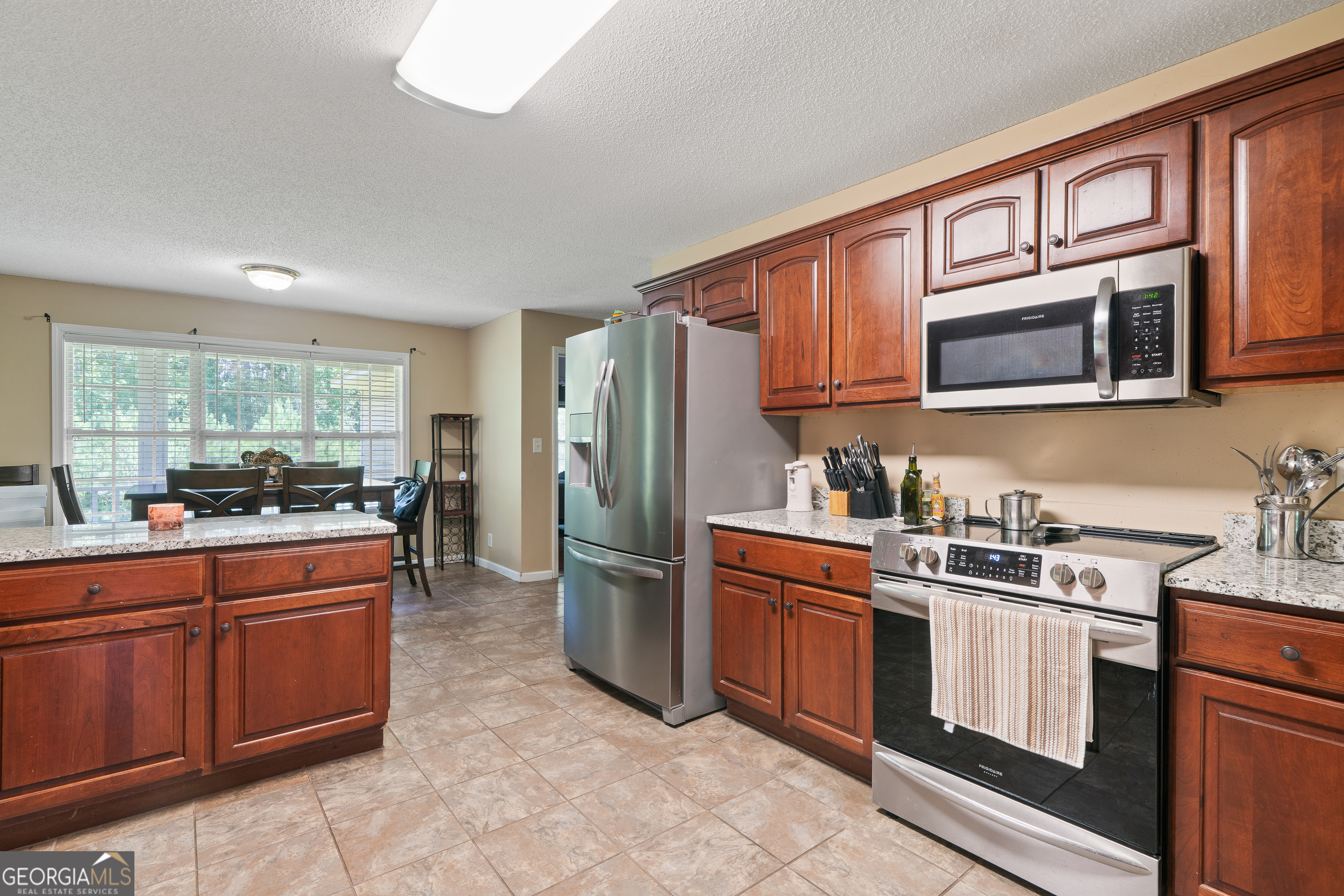 193 Virginia Avenue Gray, GA 31032 - Photo 22 of 48 a kitchen with stainless steel appliances granite countertop a stove top oven a sink dishwasher a refrigerator and cabinets with wooden floor