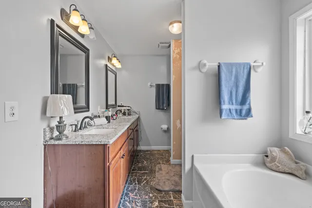 a en suite bathroom with a double vanity sink and a mirror