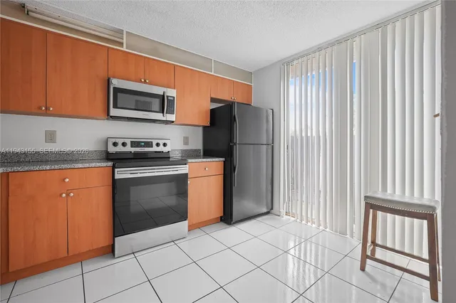a kitchen with stainless steel appliances granite countertop a refrigerator sink and cabinets