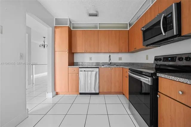 a kitchen with stainless steel appliances granite countertop a stove a sink and a refrigerator