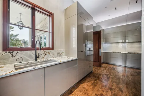a kitchen with kitchen island granite countertop a stove and a sink