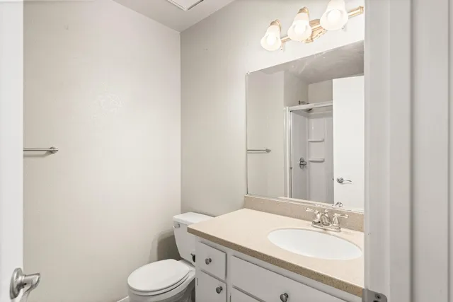 a bathroom with a granite countertop sink toilet a large mirror and shower