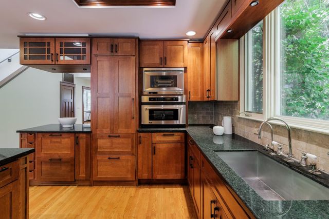 a kitchen with stainless steel appliances granite countertop a sink a stove and a refrigerator