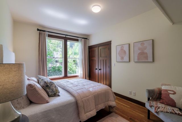 a bedroom with a bed and wooden floor