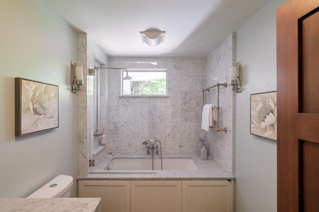 a bathroom with a granite countertop sink a toilet and shower