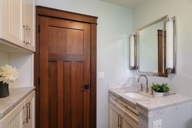 a bathroom with a granite countertop sink and a mirror