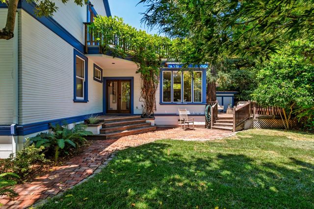 a backyard of a house with table and chairs and potted plants