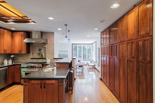 a kitchen with stainless steel appliances granite countertop a sink stove and cabinets