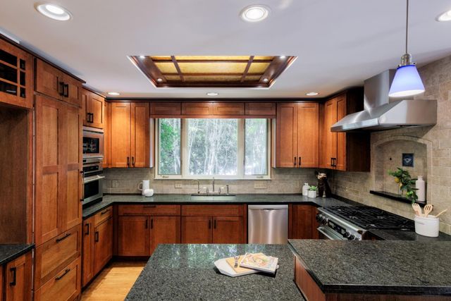 a kitchen with granite countertop a sink and a refrigerator