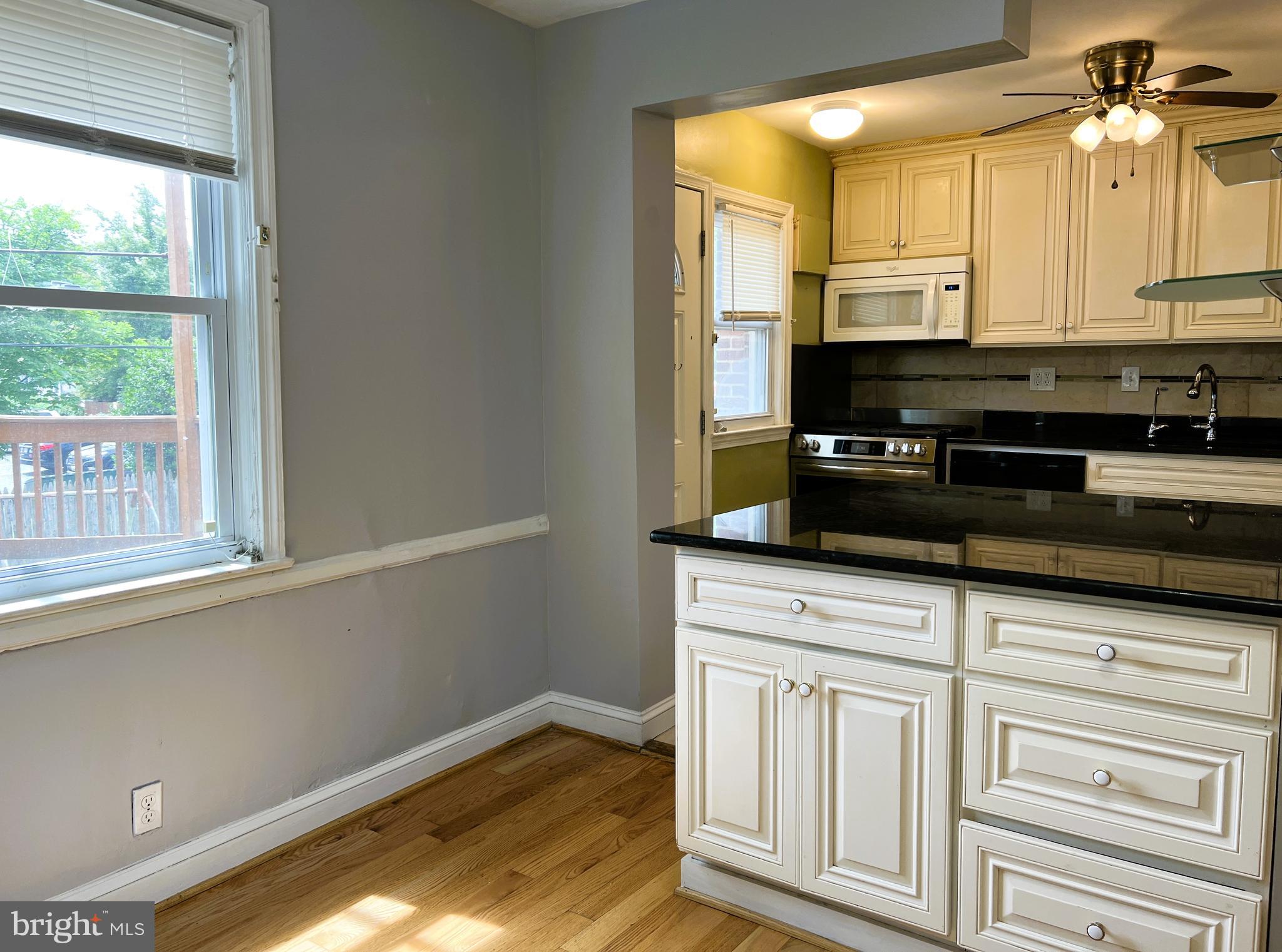 3705 Bancroft Road Baltimore, MD 21215 - Photo 13 of 50 a kitchen with granite countertop white cabinets and a window