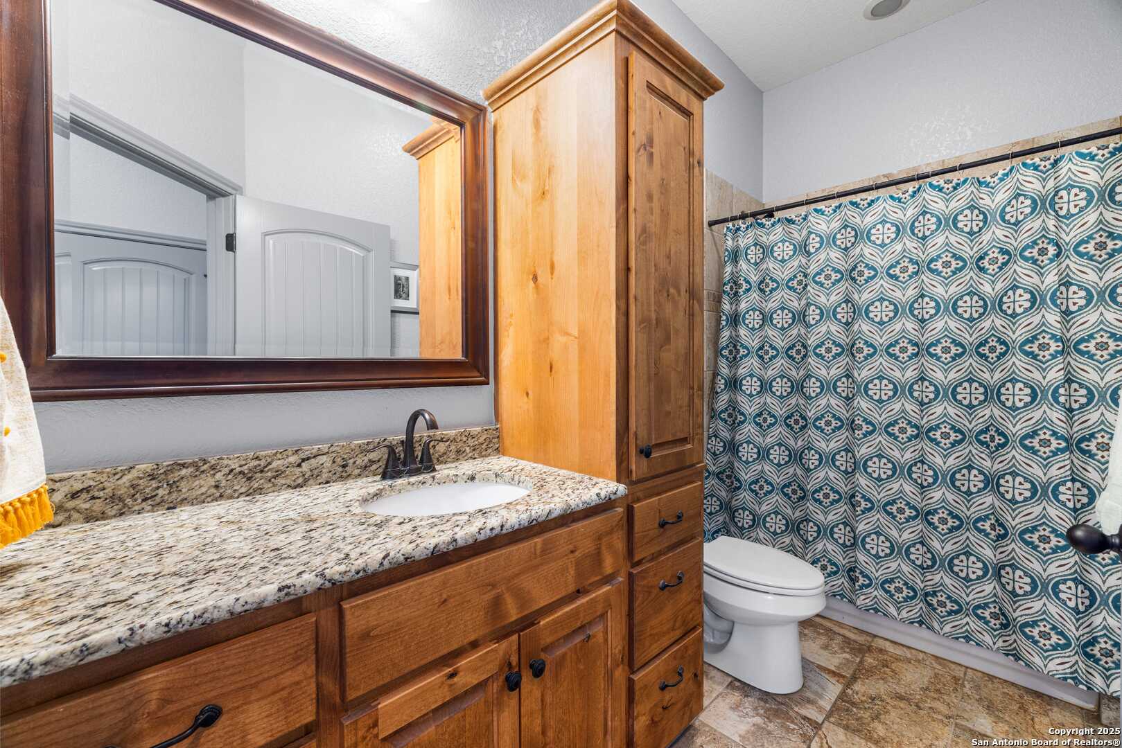 997 Kramer Road Harper, TX 78631 - Photo 23 of 45 a bathroom with a granite countertop sink and a toilet