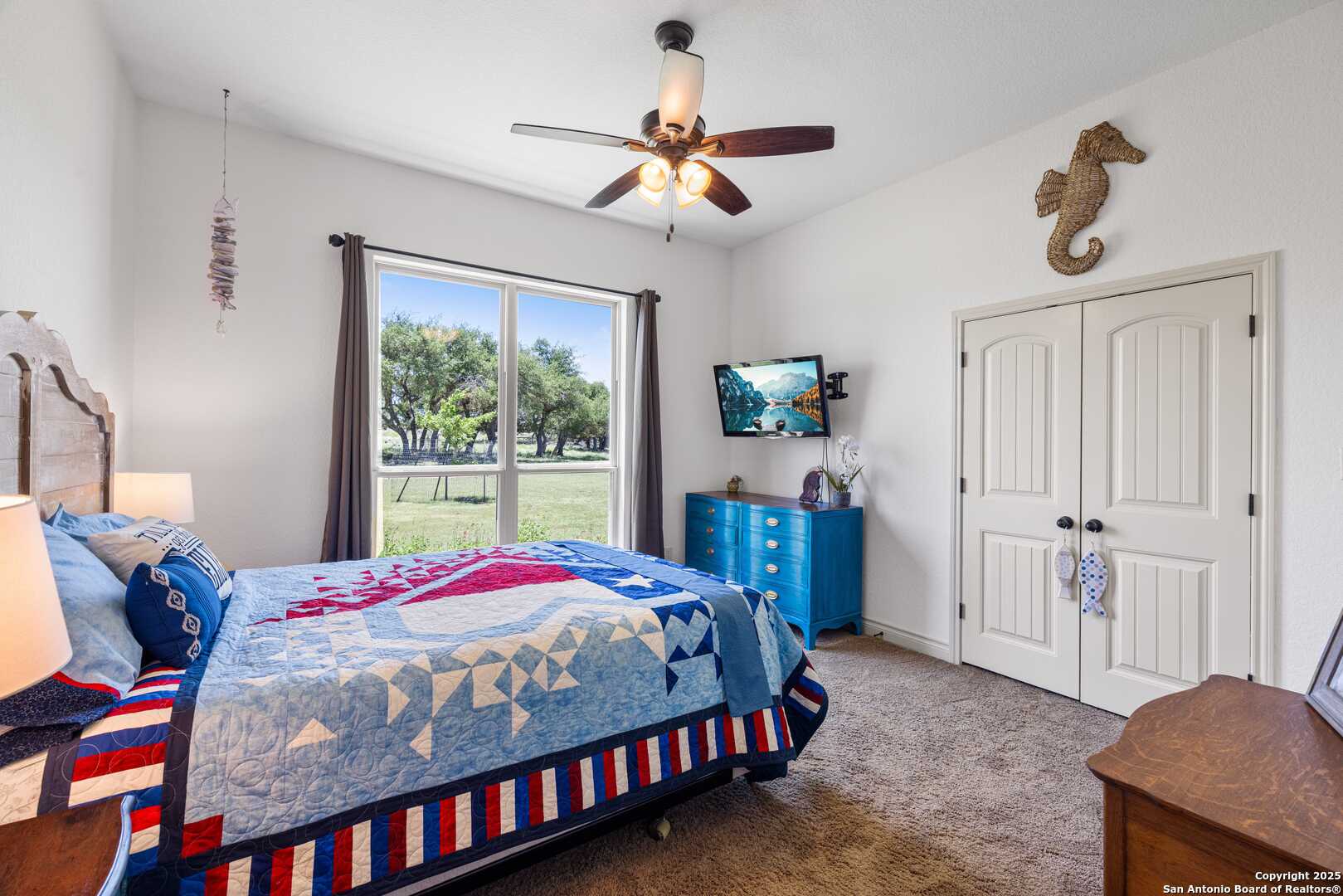 997 Kramer Road Harper, TX 78631 - Photo 24 of 45 a bedroom with a bed and a chandelier