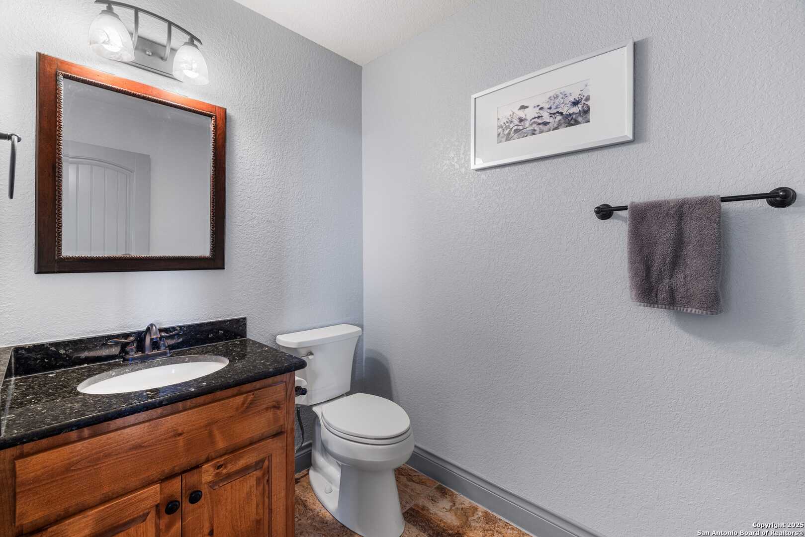 997 Kramer Road Harper, TX 78631 - Photo 26 of 45 a bathroom with a toilet sink vanity and mirror