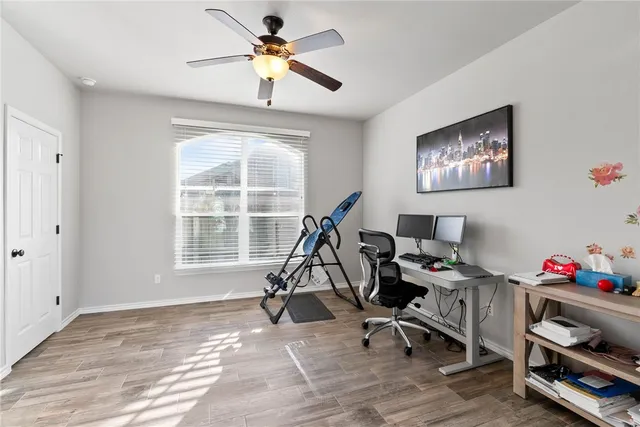 a view of a workspace with furniture and a window