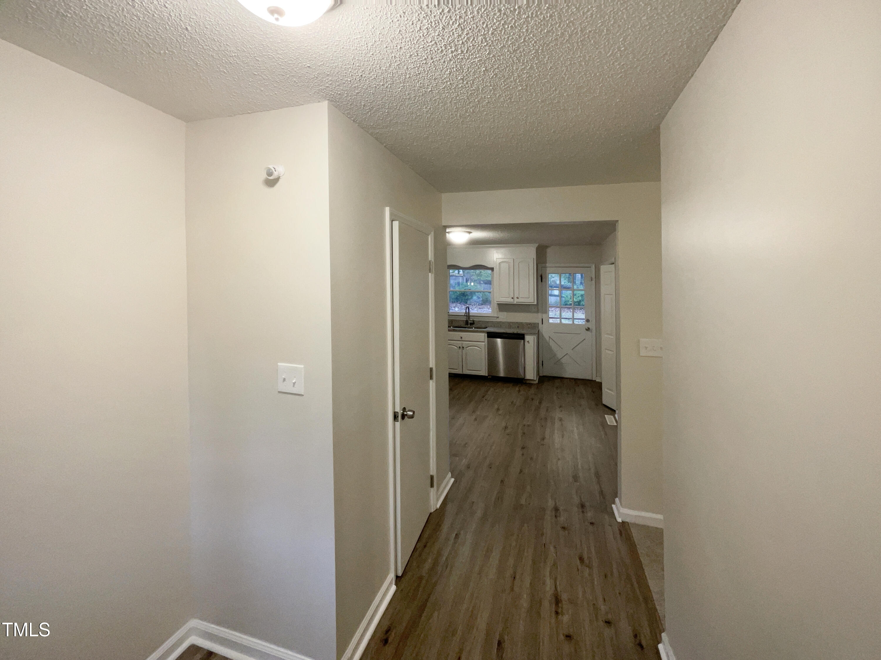 6605 Glendower Road Raleigh, NC 27613 - Photo 20 of 23 a view of a hallway with wooden floor and a living room
