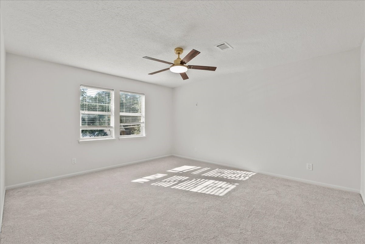 6702 Robinwick Court Spring, TX 77379 - Photo 26 of 41 an empty room with a window and a ceiling fan