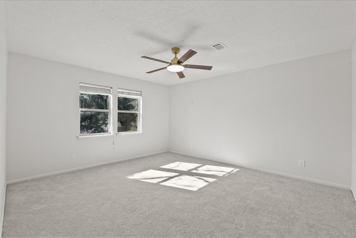 6702 Robinwick Court Spring, TX 77379 - Photo 35 of 41 an empty room with windows and ceiling fan view