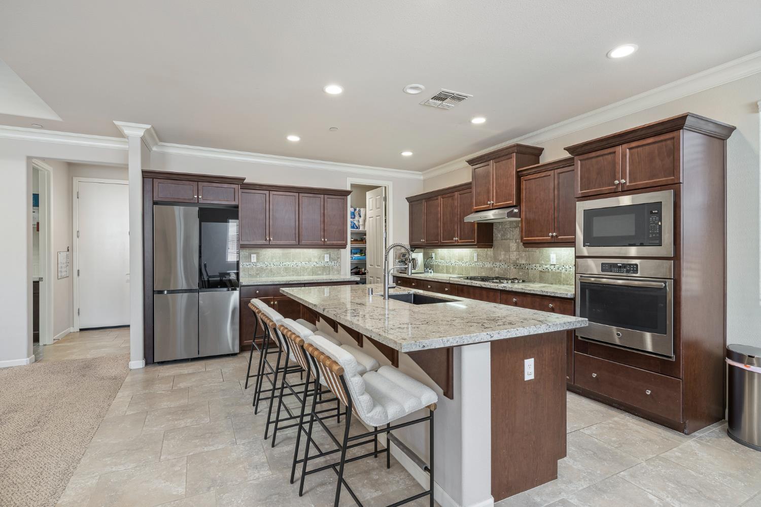 3573 Hermosa Avenue Clovis, CA 93619 - Photo 15 of 42 a kitchen with stainless steel appliances granite countertop a table chairs sink and refrigerator