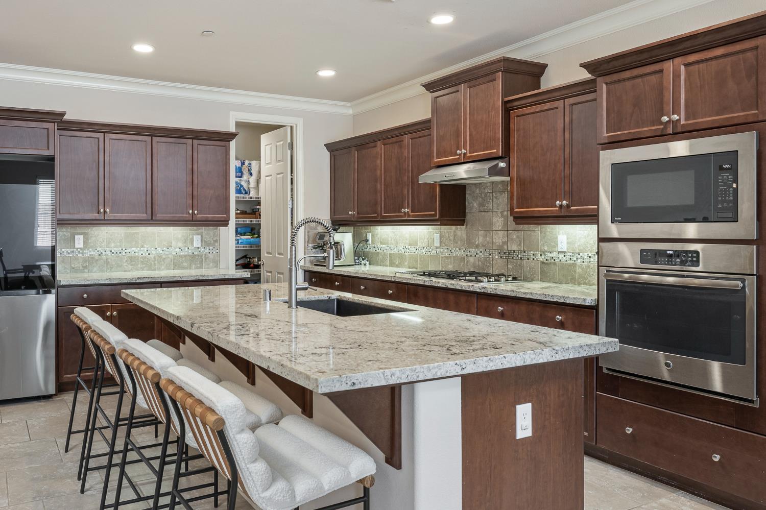 3573 Hermosa Avenue Clovis, CA 93619 - Photo 16 of 42 a kitchen with granite countertop a stove a sink and a microwave