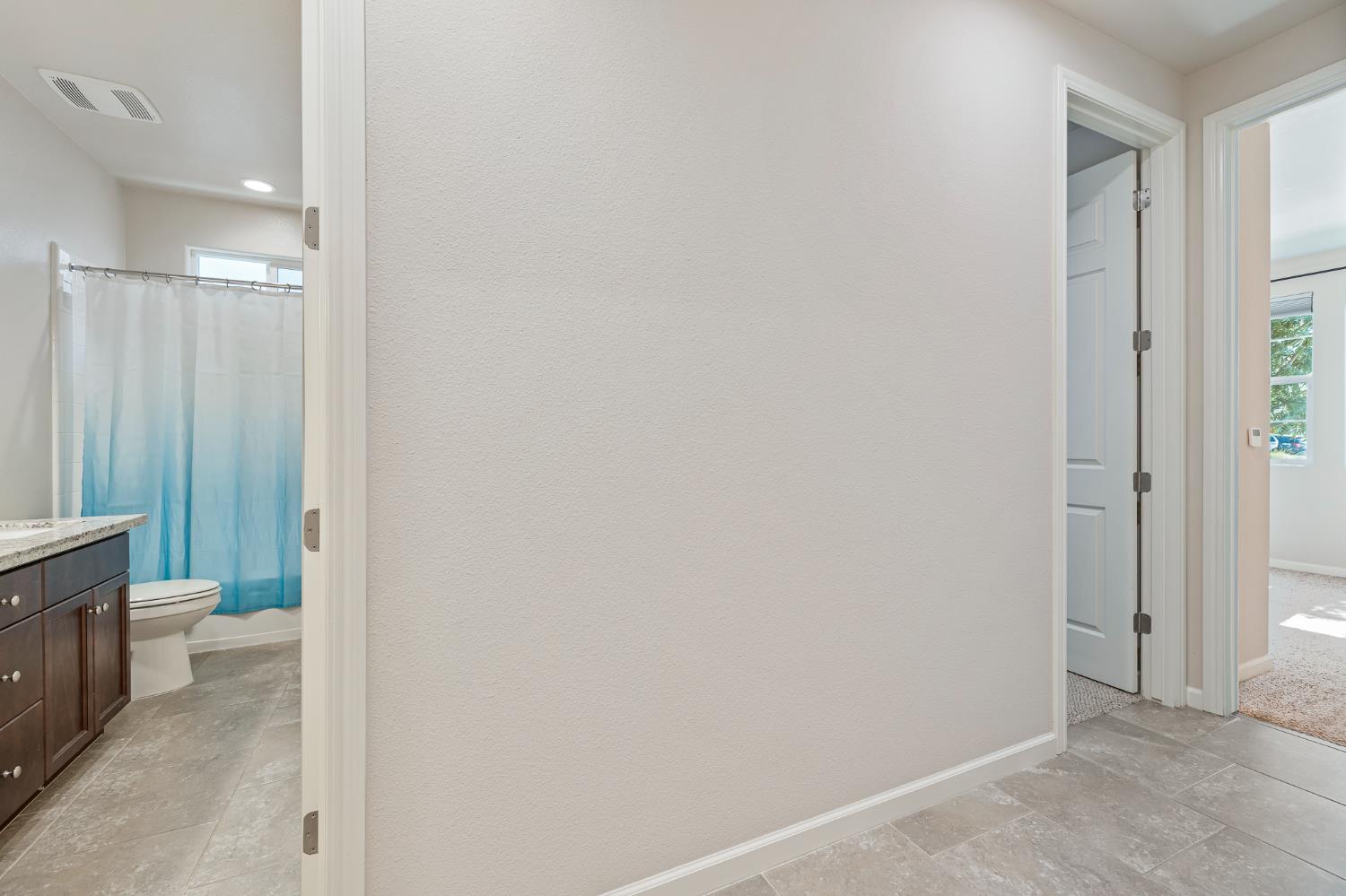 3573 Hermosa Avenue Clovis, CA 93619 - Photo 22 of 42 a bathroom with a granite countertop sink a toilet and a shower