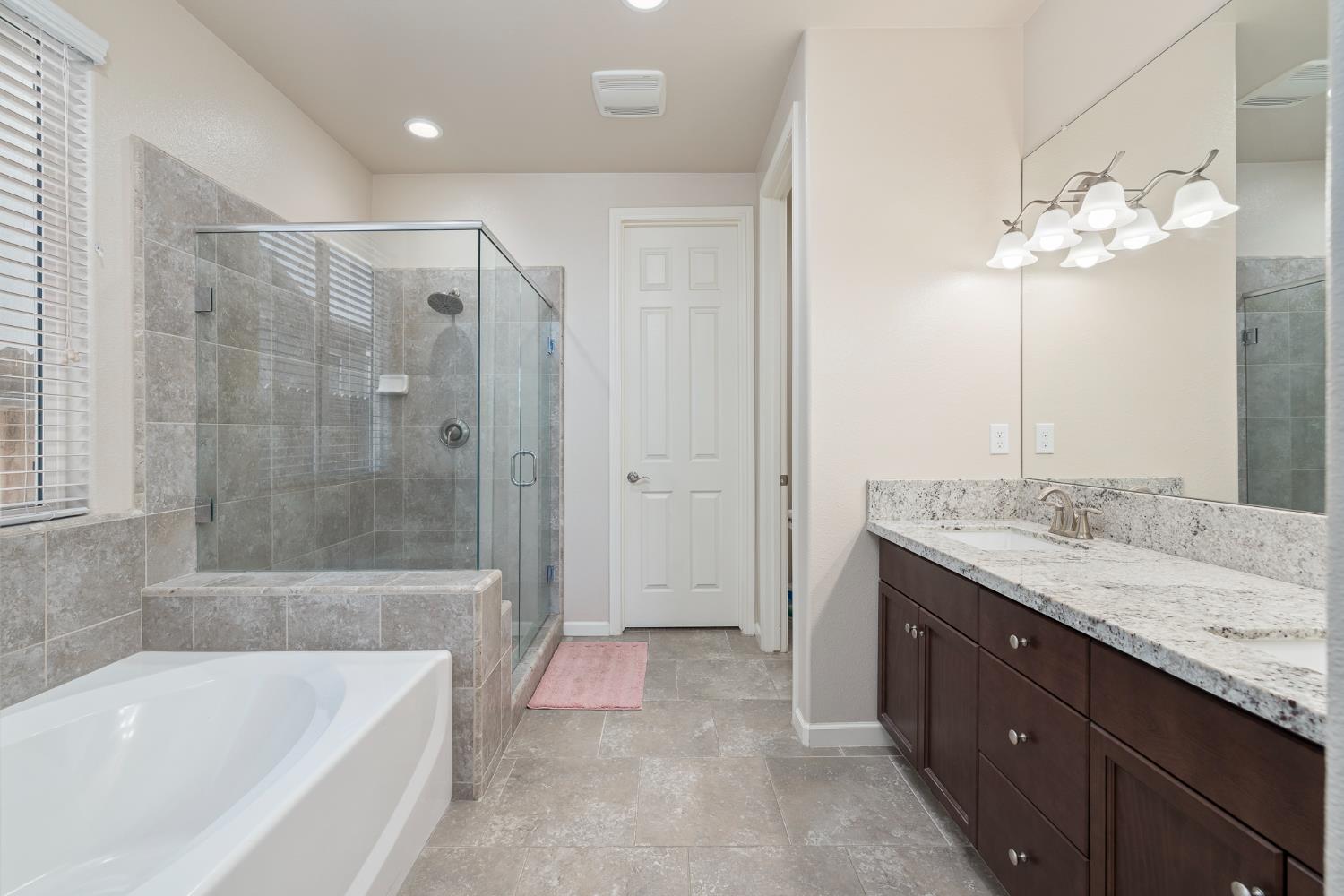 3573 Hermosa Avenue Clovis, CA 93619 - Photo 32 of 42 a bathroom with a granite countertop bathtub shower sink and mirror