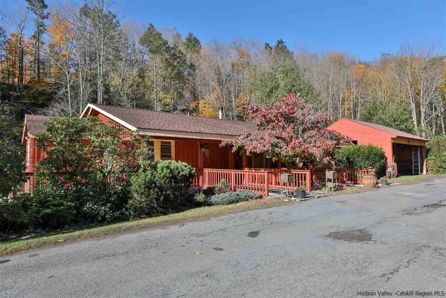 a front view of a house with a yard and mountain view