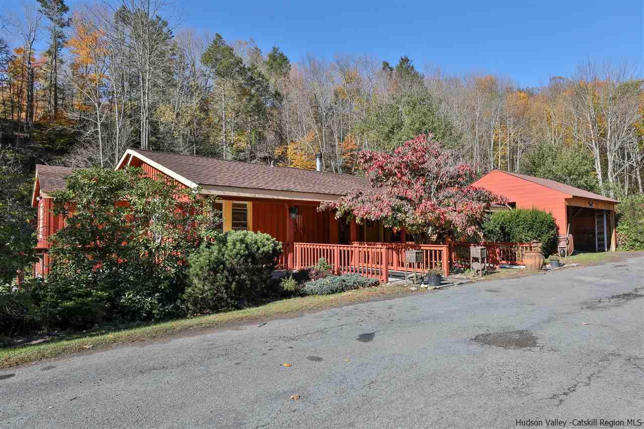 a front view of a house with a yard and mountain view