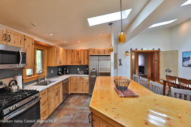 a large kitchen with kitchen island granite countertop a stove and a sink