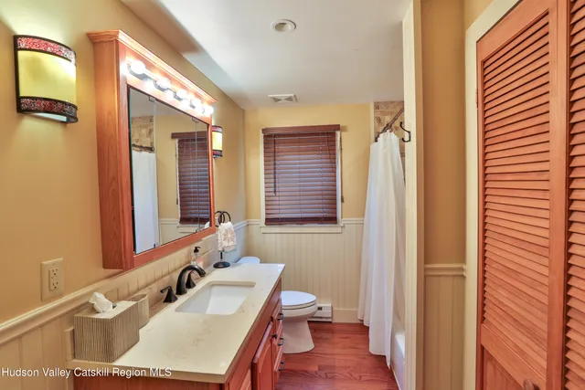 a bathroom with a sink vanity mirror and a toilet