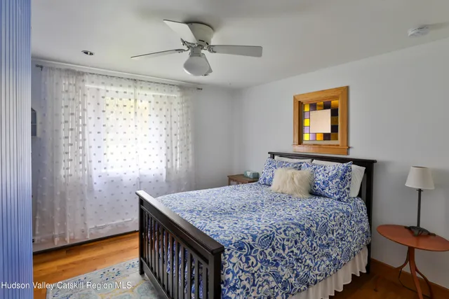 a bedroom with a bed and a dresser next to a window