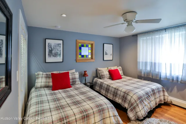 a bedroom with two beds and painting on the wall