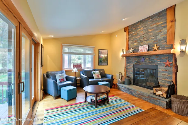 a living room with furniture a fireplace and a large window