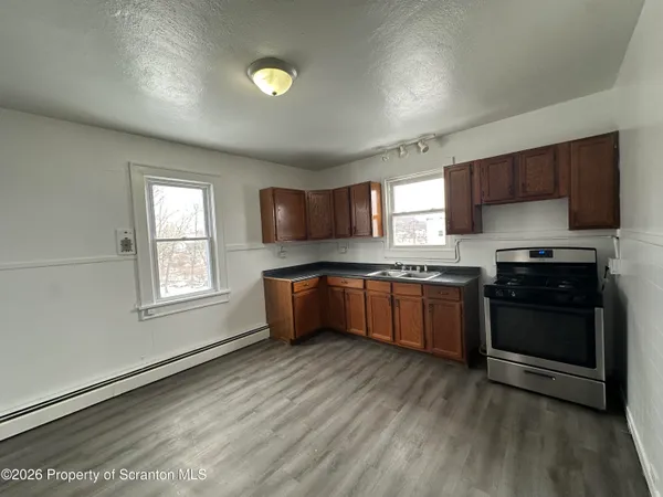 a kitchen with granite countertop a sink cabinets and stainless steel appliances