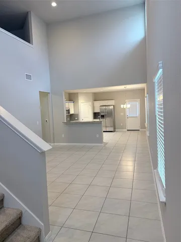 a kitchen with white cabinets and refrigerator