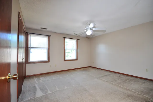 a view of an empty room with a ceiling fan