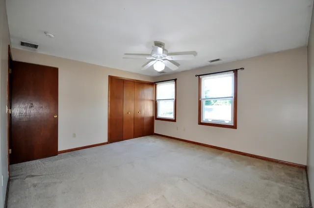 an empty room with a ceiling fan and a window