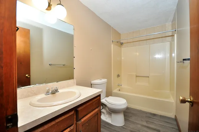 an empty room with windows and ceiling fan