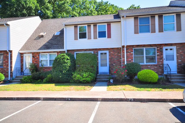 a view of a brick house with a yard and large windows