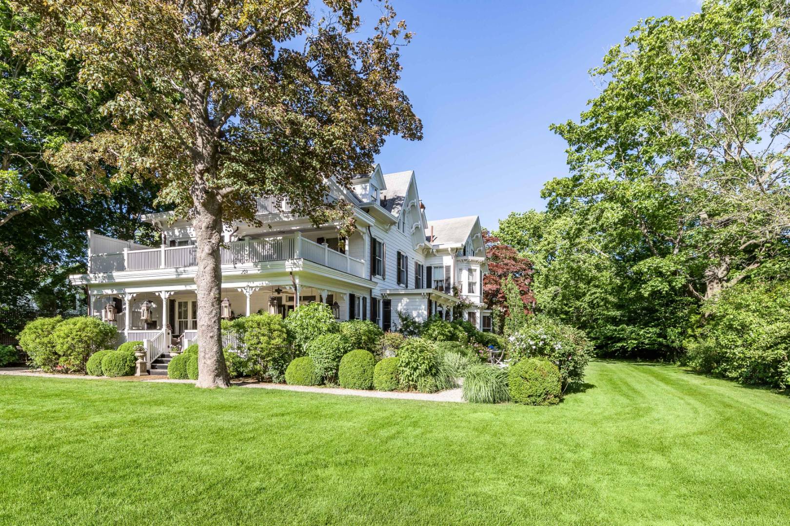 225 First Neck Lane Southampton, NY 11968 - Photo 32 of 32 a view of a house next to a big yard and large trees