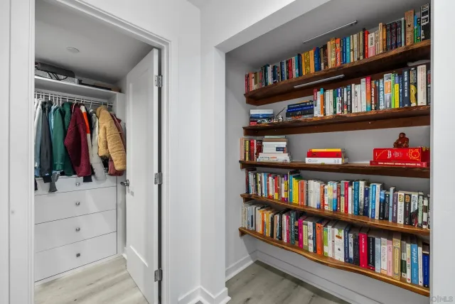 a view of walk in closet with clothes and shoes