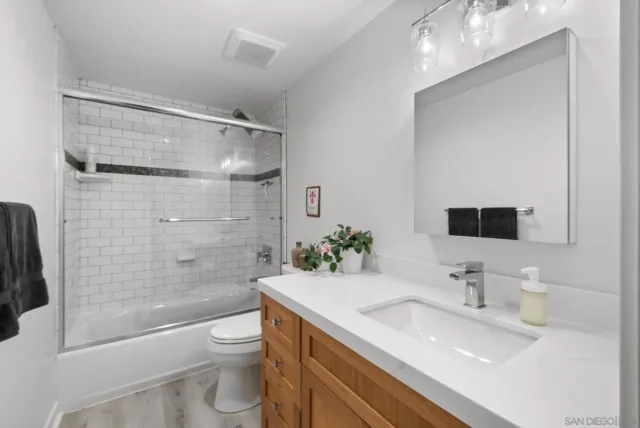 a bathroom with a granite countertop sink toilet and shower