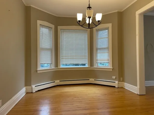 a view of room with window and wooden floor