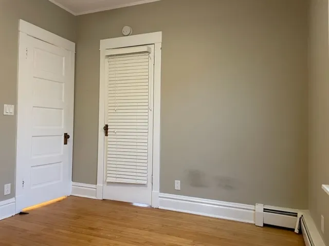 a view of a room with wooden floor and a window