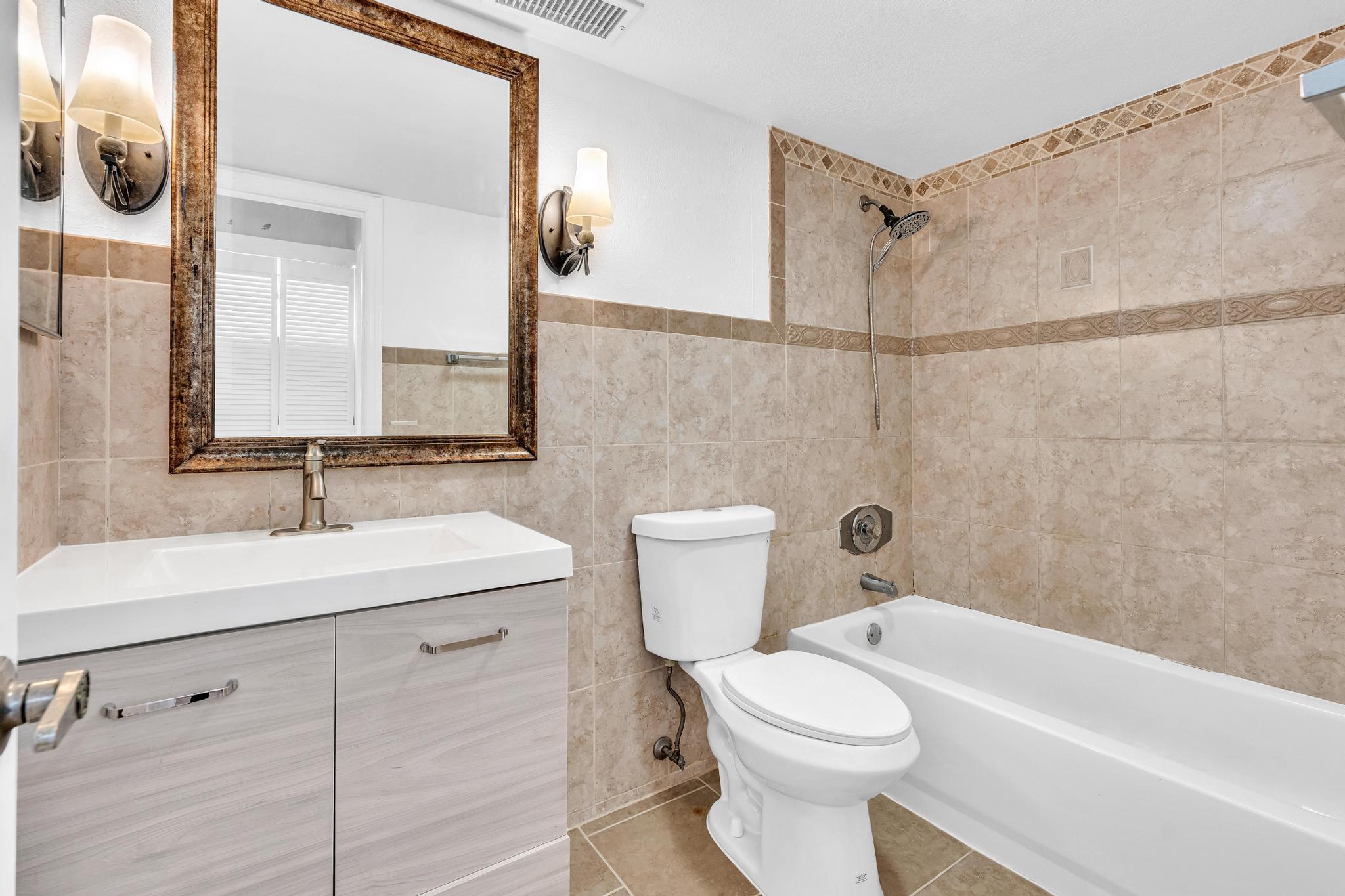 1291 Northwest 13th Street, Unit 445D Boca Raton, FL 33486 - Photo 34 of 50 a bathroom with a sink a toilet and shower