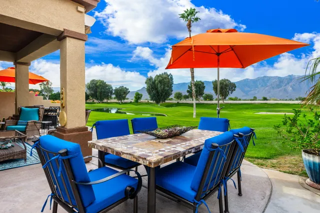 a view of an outdoor sitting area with furniture and red umbrella